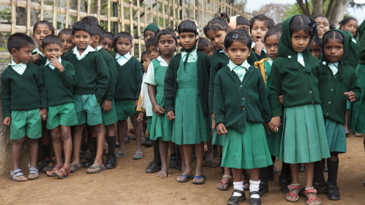 A mixed group of indian school children in green uniforms
