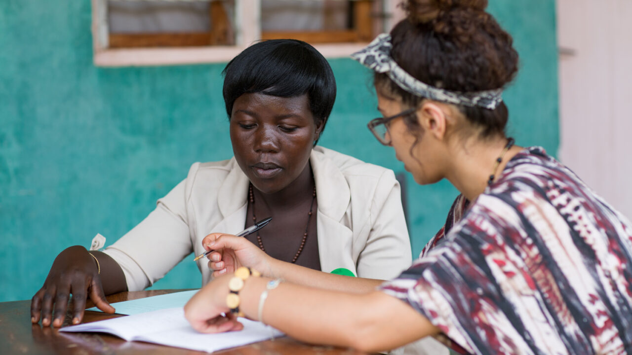 Two people going over paperwork at a table.