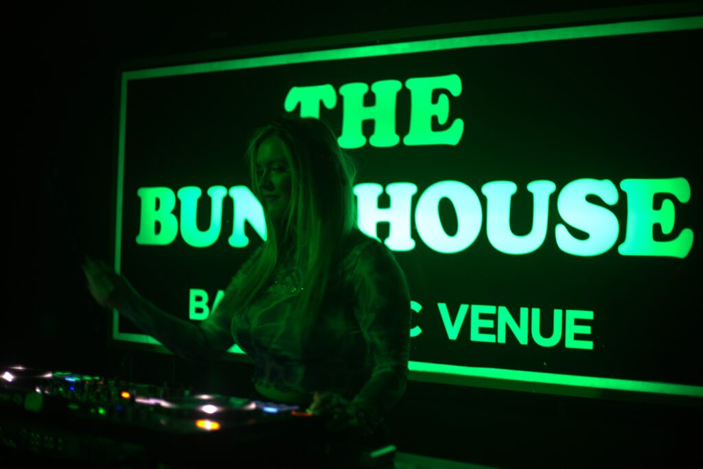 A person deejaying in the Bunkhouse bar.